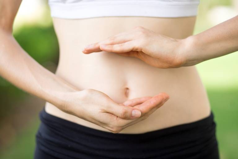 close-up-young-womans-hands-slim-belly_1262-3479